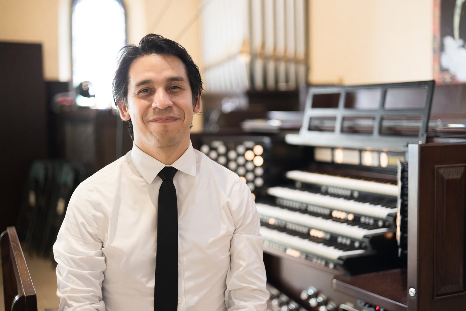 At the organ console, facing the camera